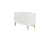 Białe łóżko dla dziecka z dodatkową barierką zabezpieczającą.