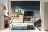 Aranżacja pokoju młodzieżowego z szafką RTV i biurkiem w odcieniach szarości.