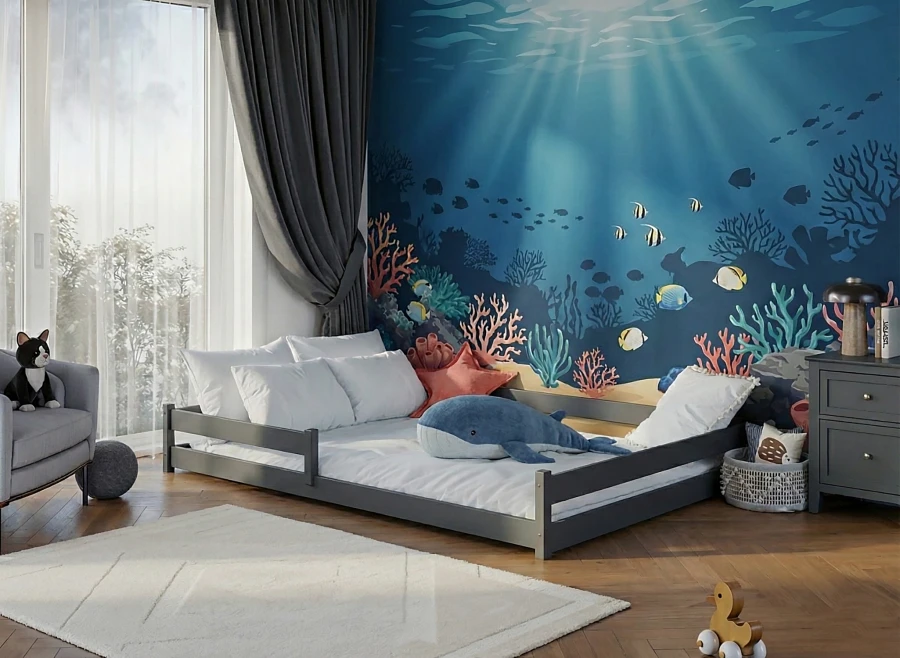 Szare łóżko parterowe Montessori w pokoju dziecięcym z fototapetą oceanu i pluszowym wielorybem.
