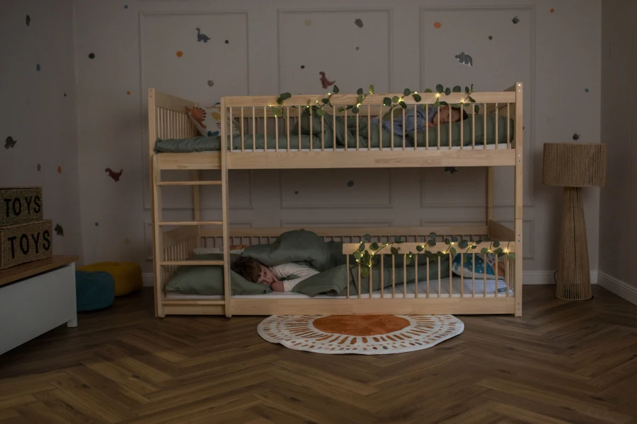 Dzieci śpiące w nocy na łóżku piętrowym ozdobionym lampkami.